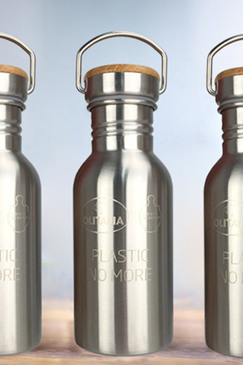 Three stainless steel water bottles with wooden caps on a wooden surface.