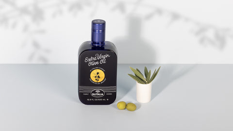 Bottle of olive oil with a label featuring olives on a white background