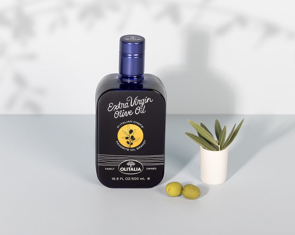Bottle of olive oil with a label featuring olives on a white background